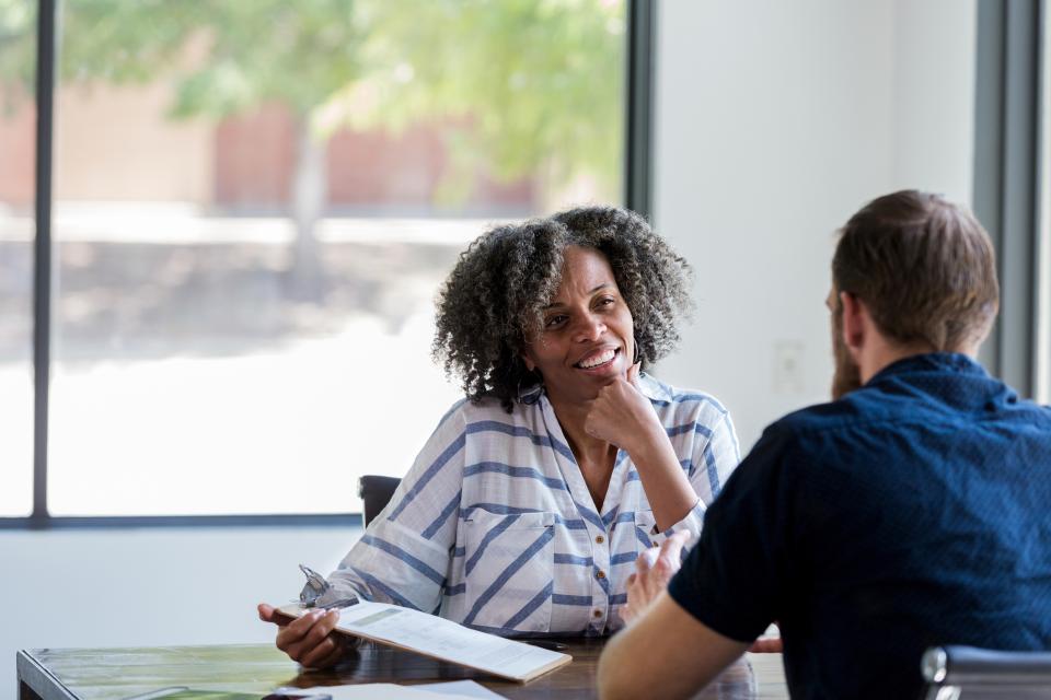 Mature businesswoman talks with male colleague stock photo