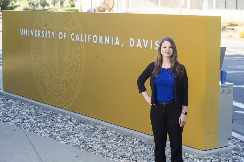 Teri Slack in front of the UC Davis sign