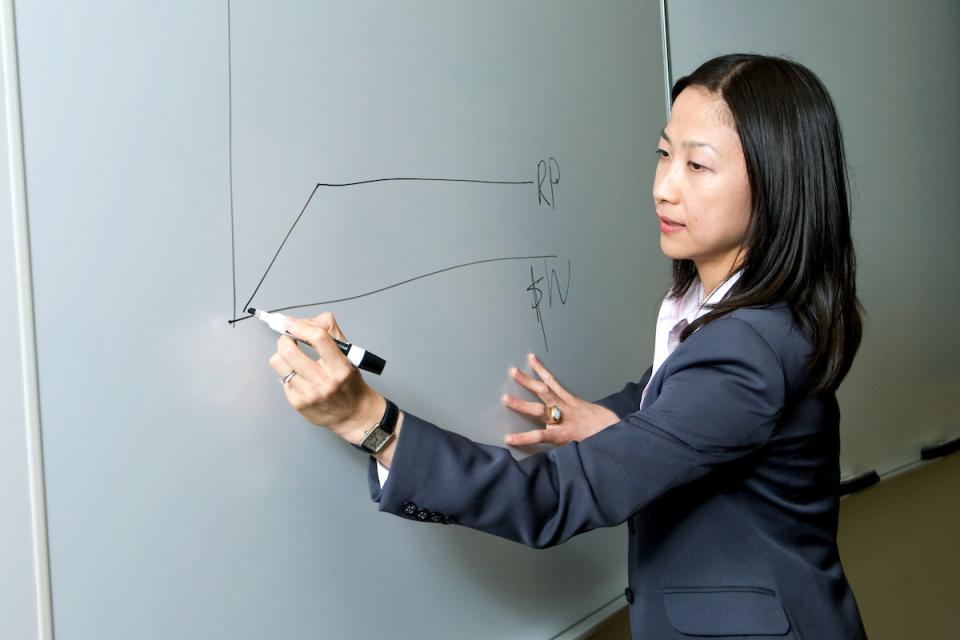 Professor Ayako Yasuda draws on a classroom white board