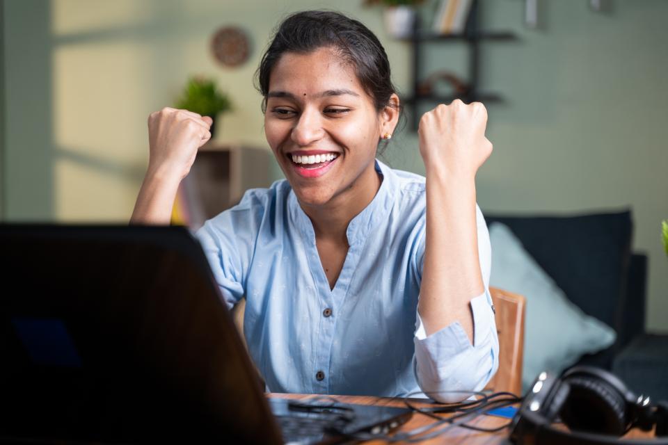 Indian woman celebrating at laptop