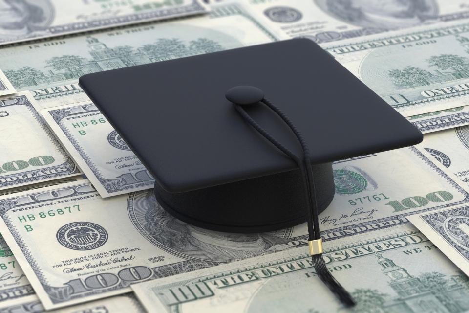 Graduation cap sitting on top of $100 bills