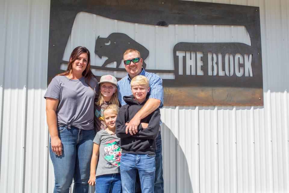 Family posing in front of a business sign