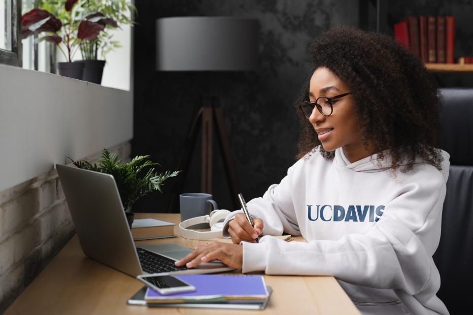 Woman at keyboard wearing UC Davis sweatshirt