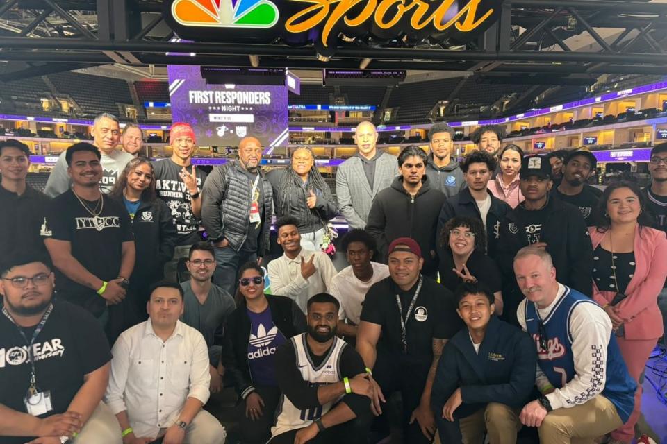 a group shot of mentees and MBA students at Golden 1 Center