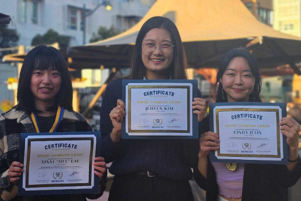 Mia Lai, Jihyun Kim and Cindy Jeon hold up their winning certificates of the Grand Champion Award 