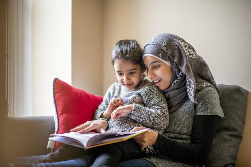 a woman holding a child and reading a book