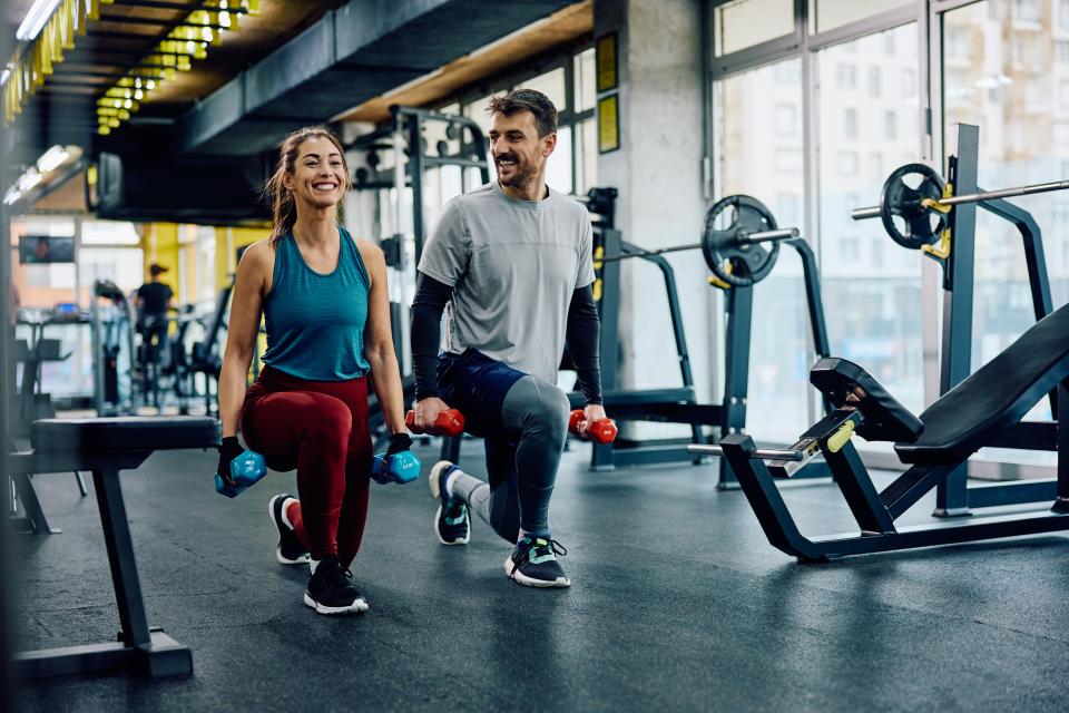 man and woman lifting weights in a gym