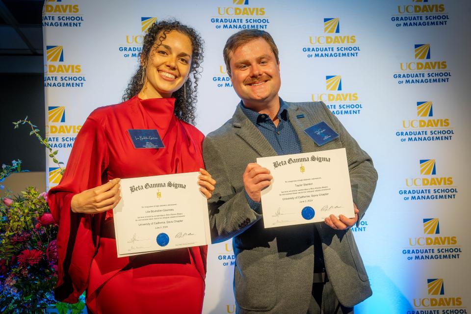 Two students holding up awards at the 2024 evening of excellence